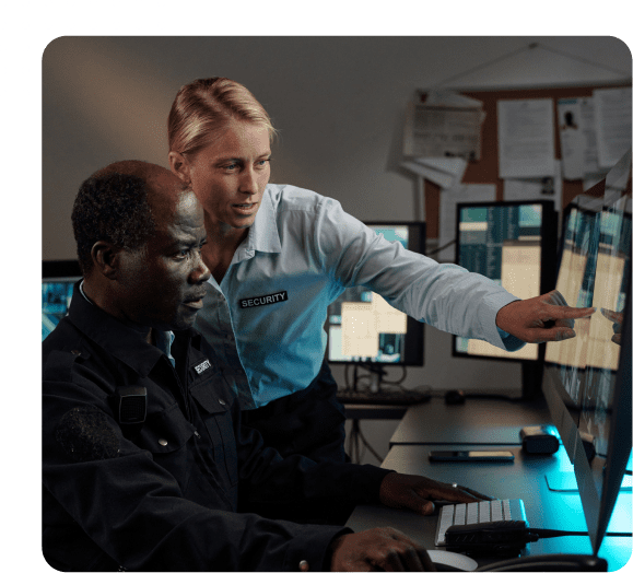 Security personnel monitoring computer screens together.